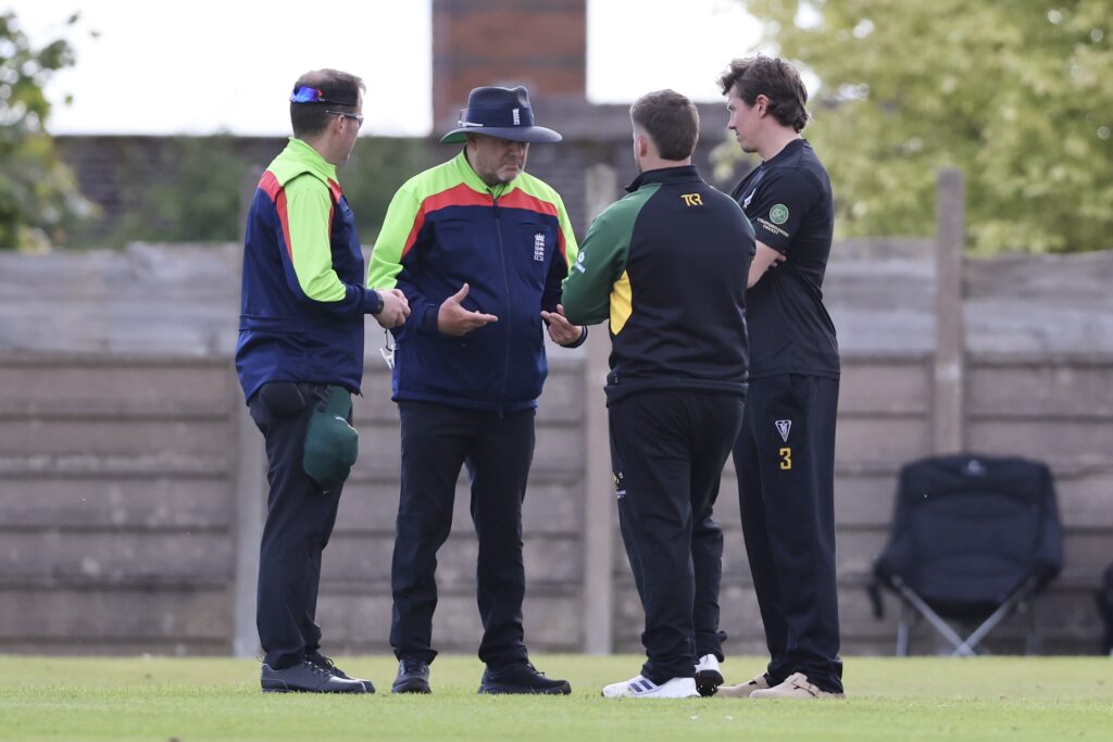 The match officials and captains discuss the situation after Lincs raised concerns over the safety of the outfield.