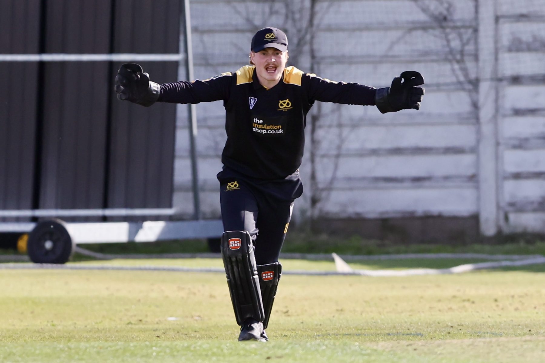 Staffordshire wicketkeeper Callum Hawkins celebrates a wicket.